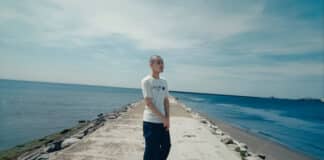 2018年2月15日。2025年4月13日。― 二人を見送ったKID FRESINOは、何を歌ったのか。 KID FRESINO standing alone on a breakwater by the sea, symbolizing loss and memory in “hikari”