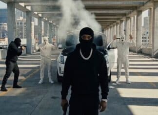 Tory Lanez『MADE YOU THINK I WAS GONE …BUT』のプロモーションビジュアルより、立体駐車場で黒いバラクラバ姿の人物を武装した集団が取り囲むシーン