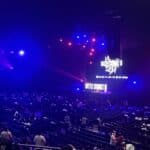 2026年8月11日のBATTLE SUMMIT III、Kアリーナ横浜の客席から見たステージ。大型スクリーンとステージ前面に大会ロゴが表示され、青と赤の照明が客席まで届いている