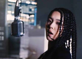 Alif Wolf beside a suspended vintage microphone in a portrait supplied for the HIPHOPCs interview
