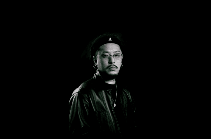 Japanese beatmaker AUDIO RADICAL standing against a black background