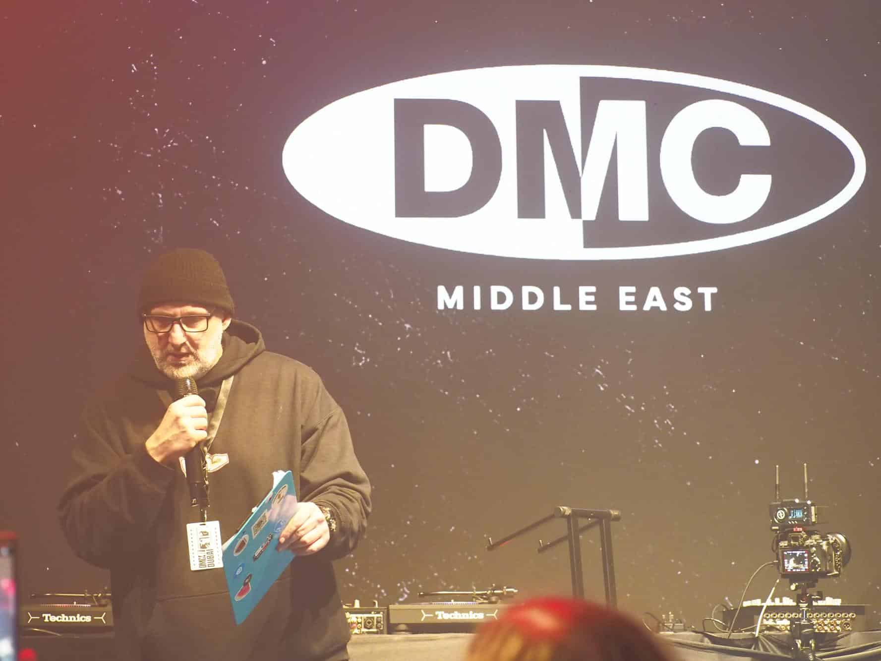 DMC Middle Eastのロゴが映るステージで、マイクを持って話すBIG HASS
