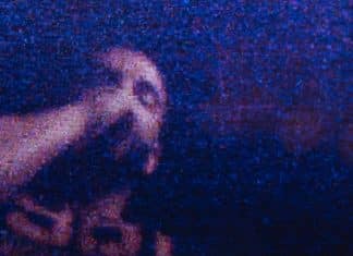 青と紫の光の中に写るDrake。公式Instagramの映像作品『FOMO』告知写真。