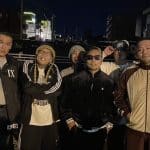 夜の屋外で5人のアーティスト仲間と並ぶ田中雄士