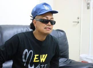 青いLAキャップと黒いサングラスを着用し、ソファに座るMAIKI BOOGIE