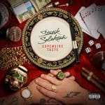 金縁の皿に「Statik Selektah」「EXPENSIVE TASTE」の文字。周囲にマイクやトランプが並ぶカバー（画像出典：Spotify）